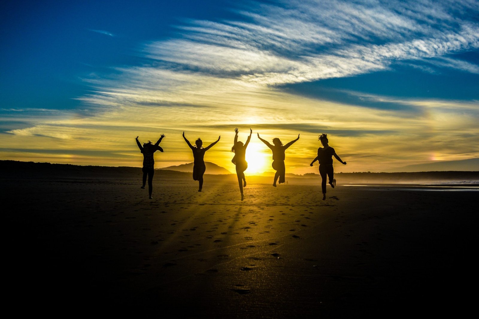 People jumping together at sunset on the beach